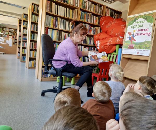 Bibliotekarz czyta książkę w tle dzieci