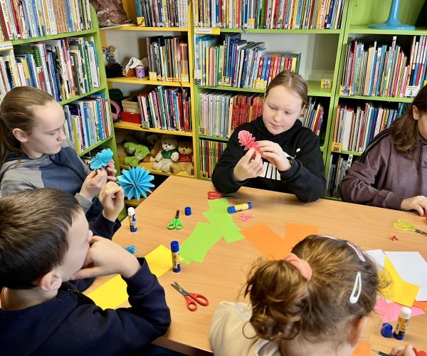 Dzieci tworzące papierowe kwiaty. 